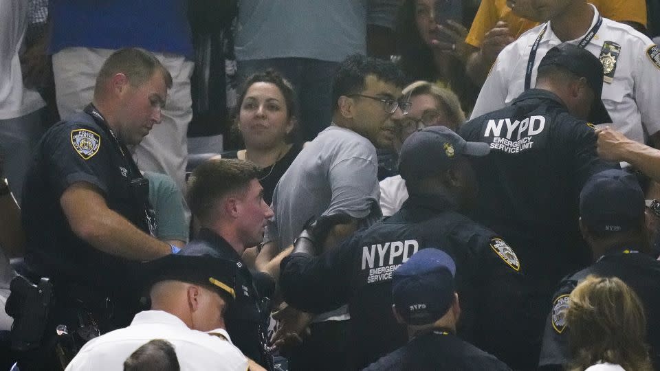 New York police officers escort a man out of the crowd. - Charles Krupa/AP