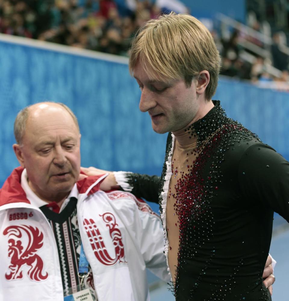 Evgeni Plushenko of Russia, right, and his coach Alexei Mishin leave after Plushenko pulled out of the men's short program figure skating competition due to illness at the Iceberg Skating Palace during the 2014 Winter Olympics, Thursday, Feb. 13, 2014, in Sochi, Russia. (AP Photo/Ivan Sekretarev)