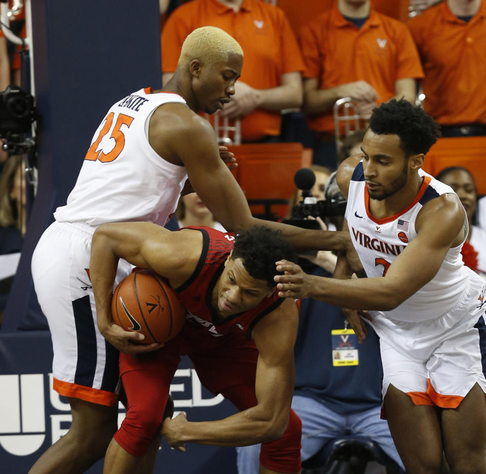 Louisville forward Dwayne Sutton, bottom, battles for a rebound with Virginia forward Mamadi Diakite (25) and Virginia guard Braxton Key (2) during the first half of an NCAA college basketball game in Charlottesville, Va., Saturday, March 9, 2019. (AP Photo/Steve Helber)