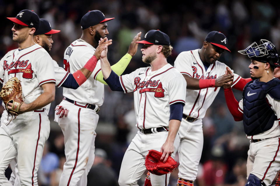 Atlanta Braves relief pitcher A.J. Minter, center, celebrates with teammates after a win over the Arizona Diamondbacks in a baseball game Saturday, July 30, 2022, in Atlanta. (AP Photo/Butch Dill)