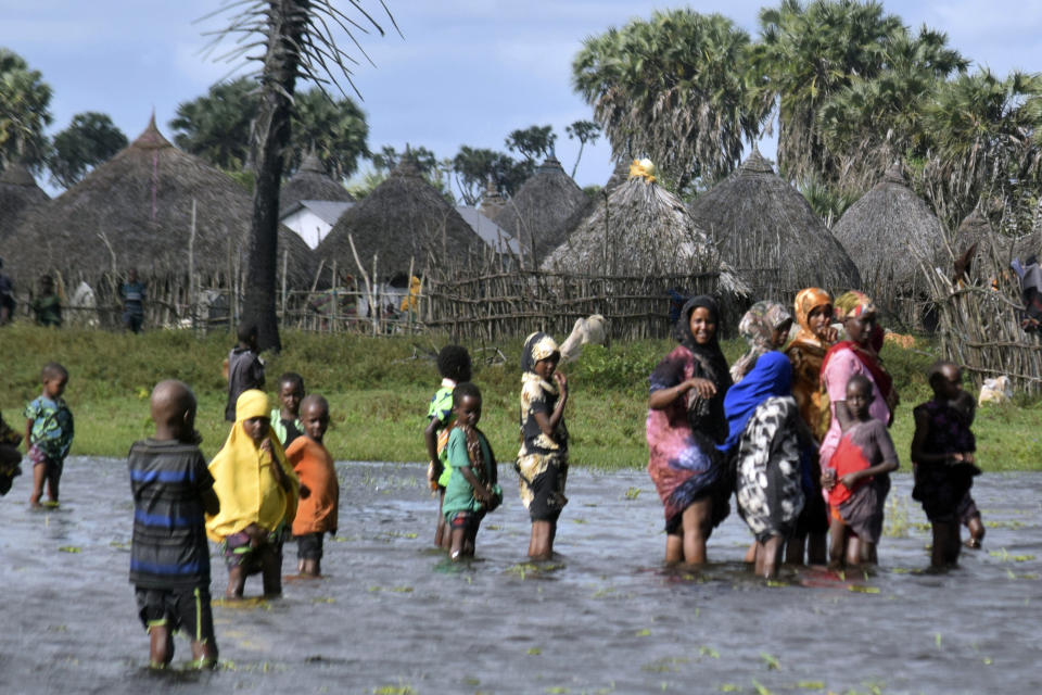 Residents are seen in the flooded village of Lumshi in Mpeketoni within Lamu County, Kenya, Friday Nov. 17 2023. Unrelenting rainfall across Kenya's northern counties and the capital, Nairobi, has led to widespread flooding, displacing an estimated 36,000 people and killing 46 people since the beginning of the rainy season less than a month ago.(AP Photo/Gideon Maundu).