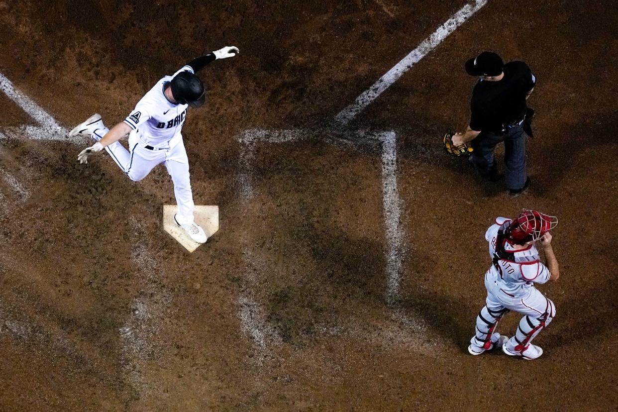 Arizona Diamondbacks' Pavin Smith celebrates after scoring the game winning run past Philadelphia Phillies catcher J.T. Realmuto on a single by Ketel Marte during the ninth inning in Game 3 of the baseball NL Championship Series in Phoenix, Thursday, Oct. 19, 2023. (AP Photo/Brynn Anderson)