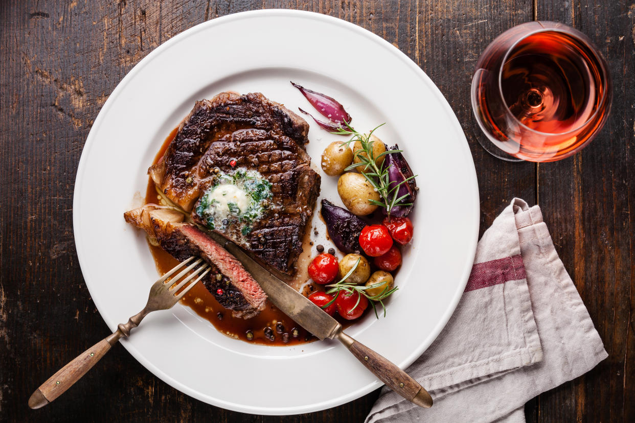 A steak dinner with a glass of wine