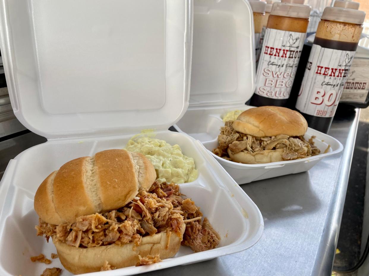 Freshly-made pulled pork and bourbon chicken sandwiches sit on the counter waiting to be handed out to a customer of Henn House BBQ on Thursday, May 19 at Reserve Artisan Ales in Galesburg