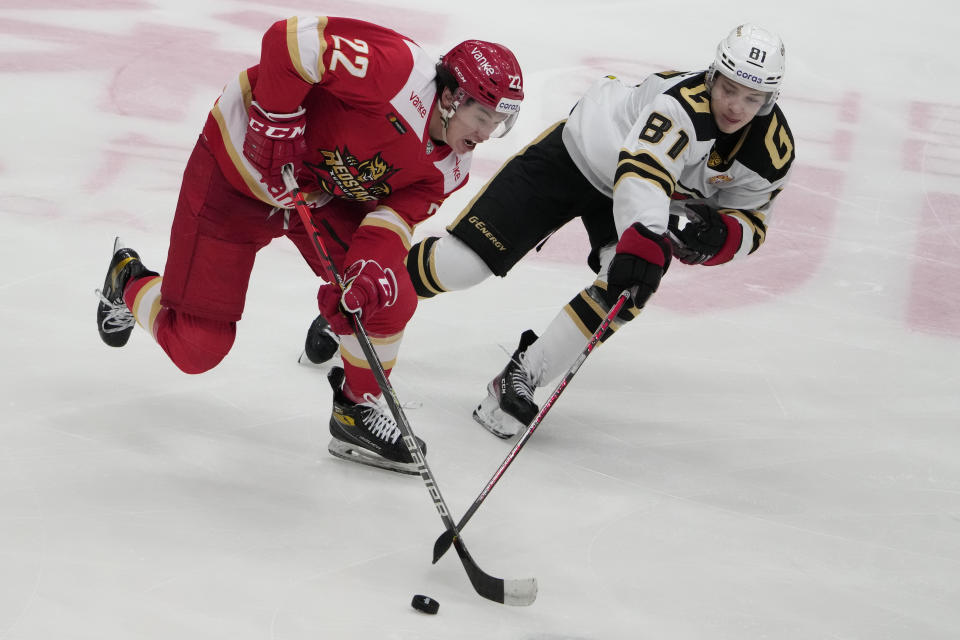 Kunlun Red Star's Parker Foo, left, and Avangard's Arseny Gritsyuk battle for the puck during the Kontinental Hockey League ice hockey match between Kunlun Red Star Beijing and Avangard Omsk in Mytishchi, outside Moscow, Russia, Wednesday, Nov. 17, 2021. (AP Photo/Pavel Golovkin)