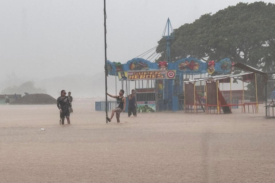 Residents negotiate floods caused by powerful Typhoon Krathon locally called ‘Typhoon Julian’ at Bacarra, Ilocos Norte province, northern Philippines (AP)