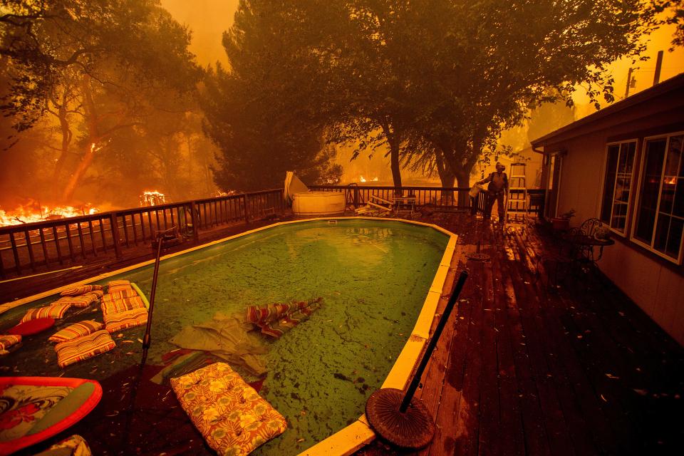 A firefighter gathers water from a pool while battling the Ranch Fire near Clearlake Oaks, Calif., on Aug. 4. (Photo: Noah Berger/AFP/Getty Images)