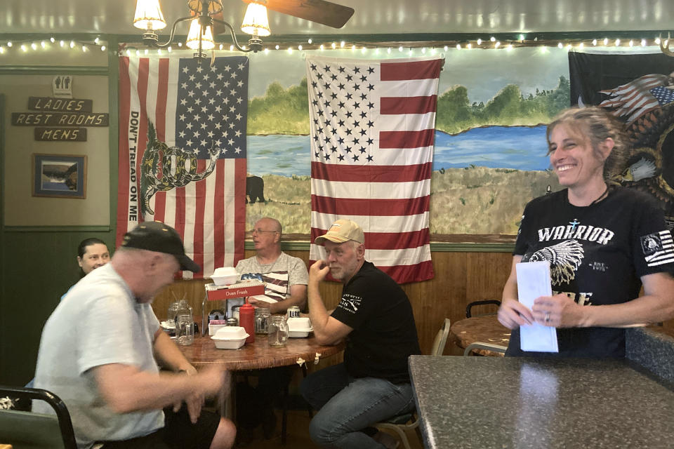 FILE - Pauline Bauer, right, speaks with customers from left, Ron Stevenson, 68, of Jamestown, N.Y., his cousin Glenn Robinson, 68, of Kane, Pa., and his half-brother Paul Boedecker, 71, of Warren, Pa., at Bauer's restaurant, Bob's Trading Post, July 21, 2021, in Hamilton, Pa. Bauer, who screamed death threats directed at then-House Speaker Nancy Pelosi while storming the U.S. Capitol on Jan. 6, 2021, was sentenced on Tuesday to two years and three months in prison. (AP Photo/Michael Kunzelman, File)