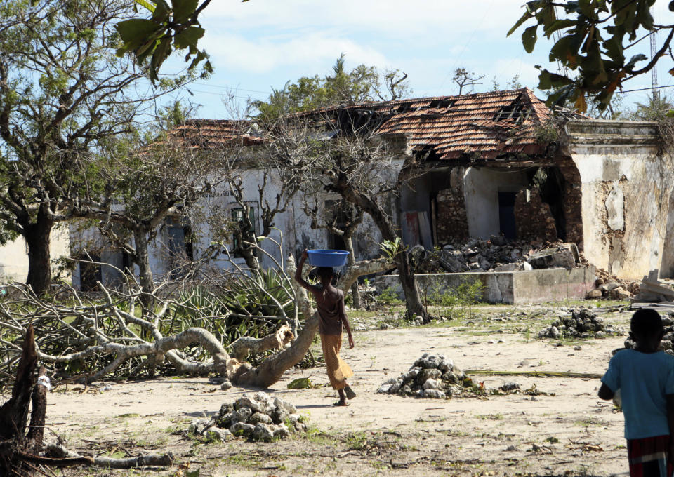 Children walk past a house damaged by Cyclone Kenneth when it struck Ibo island north of Pemba city in Mozambique, Wednesday, May, 1, 2019. The government has said more than 40 people have died after the cyclone made landfall on Thursday, and the humanitarian situation in Pemba and other areas is dire. More than 22 inches (55 centimeters) of rain have fallen in Pemba since Kenneth arrived just six weeks after Cyclone Idai tore into central Mozambique. (AP Photo/Tsvangirayi Mukwazhi)