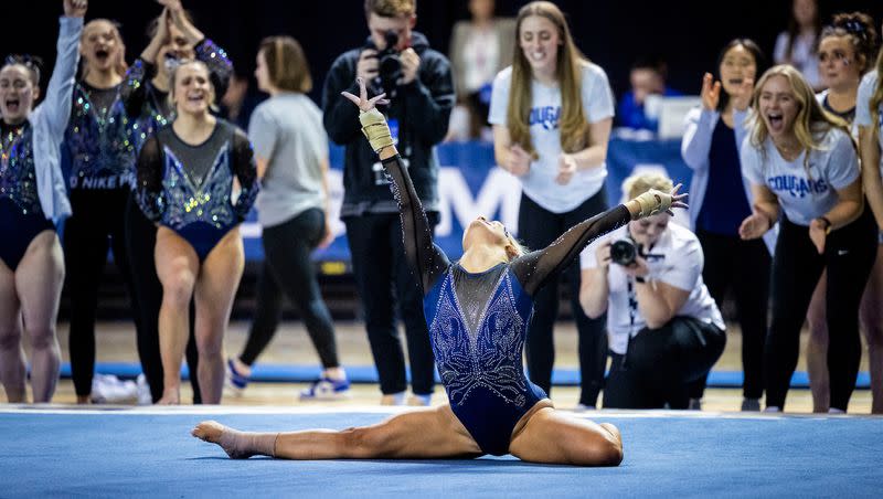 BYU gymnasts react after a teammate finishes floor routine against Utah State during 2023 season.