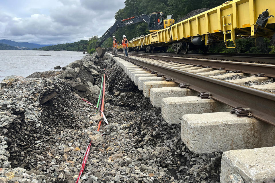 In this photo provided by the Metropolitan Transit Authority, MTA workers assess flood damage to train tracks after a flash flood, Monday, July 10, 2023, near Manitou, N.Y. Heavy rain has washed out roads and forced evacuations in the Northeast as more downpours were forecast throughout the day, Monday. (Courtesy of the MTA via AP)