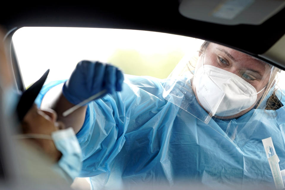 Shania Dod, right, collects a sample at a United Memorial Medical Center COVID-19 testing site, Wednesday, July 8, 2020, in Houston. (AP Photo/David J. Phillip)