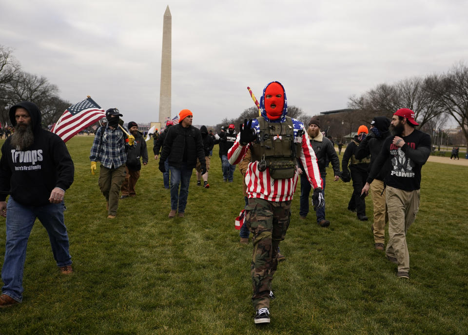 FILE - People march towards the U.S. Capitol with those who say they are members of the Proud Boys in Washington, Jan. 6, 2021. An upcoming hearing of the U.S. House Committee probing the Jan. 6 insurrection is expected to examine ties between people in former President Donald Trump's orbit and extremist groups who played a role in the Capitol riot. (AP Photo/Carolyn Kaster, File)