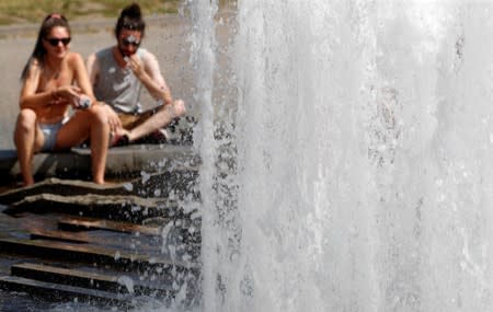 People cool off as temperatures reach new record highs in a fountain at the Berlin cathedral