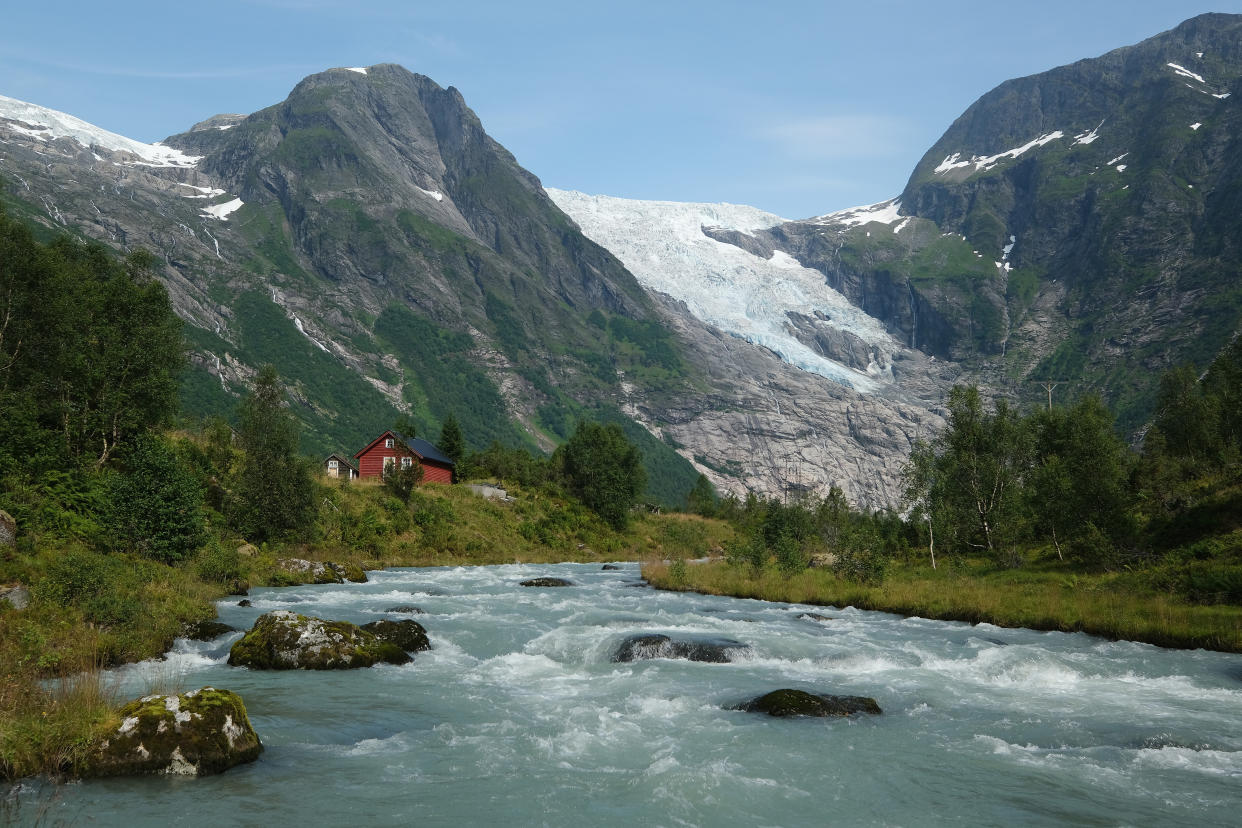 The Boyabreen glacier in Norway lies above rock it ground smooth and once covered deep in ice. Meltwater rushes down a stream past cabins in August 2020. (Photo: Sean Gallup via Getty Images)