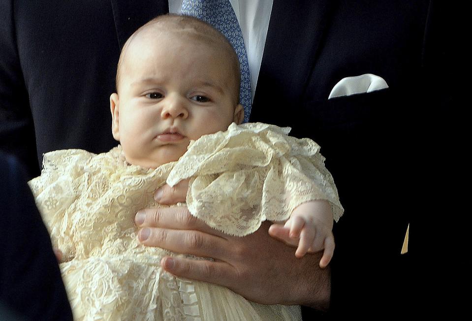 Britain's Prince William carries his son Prince George as they arrive for his son's christening at St James's Palace in London