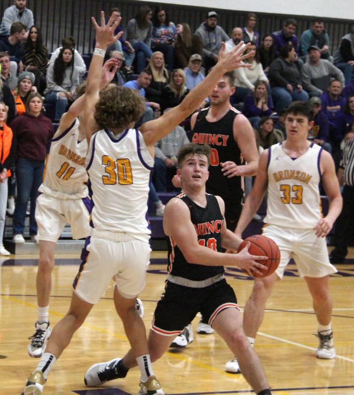 Quincy&#39;s Sam Sawyer (10) weaves his way to the bucket for two points while Bronson&#39;s Reagan Mayer (30), Kamron Brackett (11) and Jordan Shadix (33) defend.