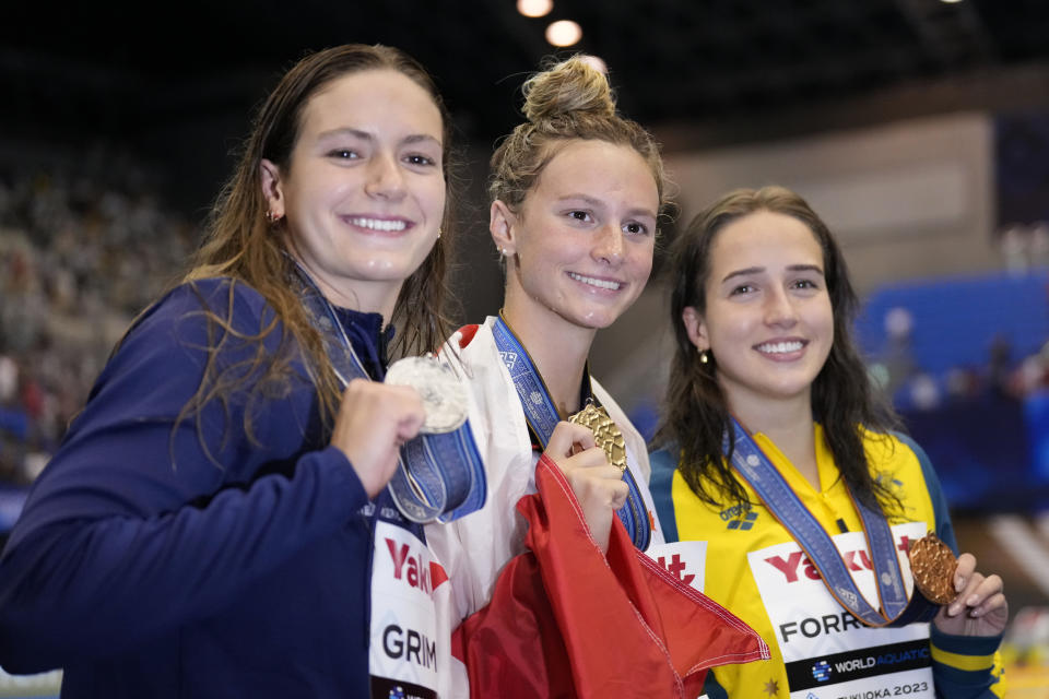 Medalists, from left to right, Katie Grimes of the U.S., silver, Summer McIntosh of Canada, gold, and Jenna Forrester of Australia, bronze celebrate during the medal ceremony for the women's 400m medley at the World Swimming Championships in Fukuoka, Japan, Sunday, July 30, 2023. (AP Photo/Lee Jin-man)