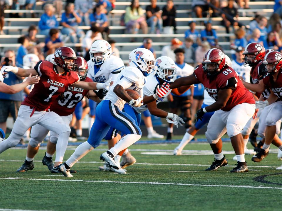 Newark's Austin Rose, left, and Jesiah Draper try to tackle Zanesville's Kam Ruff on Friday night at John D. Sulsberger Memorial Stadium.