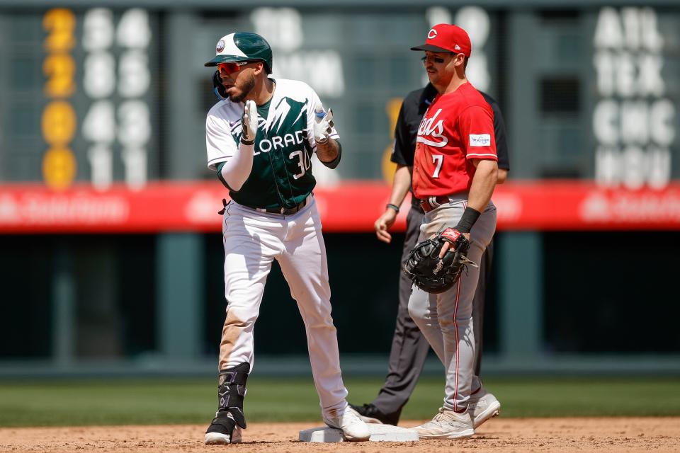 Colorado Rockies second baseman Harold Castro reacts ahead of Cincinnati Reds first baseman Spencer Steer after hitting a double