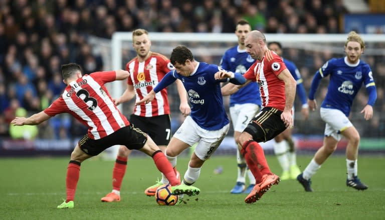 Everton's midfielder Ross Barkley (C) tries to dribble through Sunderland's midfielder Darron Gibson (R) and defender Bryan Oviedo (L) during the English Premier League football match February 25, 2017