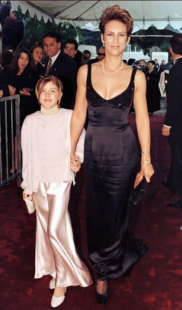 mother and daughter walking the red carpet at the globes in shiny pink and black dresses