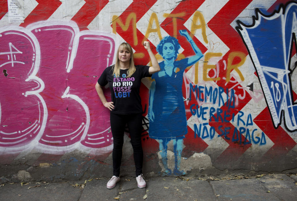 In this Sept. 20, 2018 photo, Barbara Aires, 35, poses for a photo next to a mural of slain councilwoman Marielle Franco, in Rio de Janeiro, Brazil. Aires is one of 53 transgender candidates running for state and federal offices in Brazil, a deeply conservative and religious country that is also one of the most dangerous in the world for transsexuals. (AP Photo/Silvia Izquierdo)