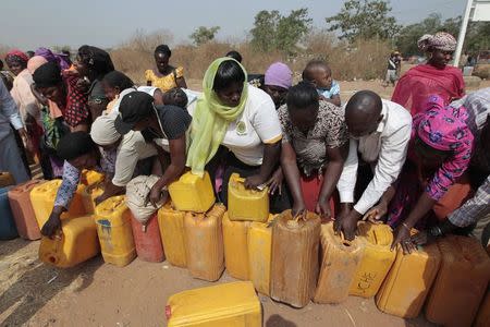 People place their containers in the queue for the sale of kerosene cooking fuel ahead of the launch of the "kero correct" scheme at a Nigerian National Petroleum Corporation (NNPC) mega petrol station in Abuja January 23, 2015. REUTERS/Afolabi Sotunde/Files