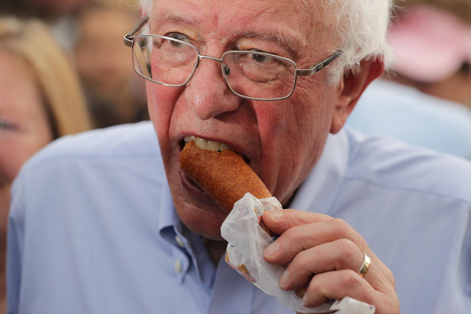 Sen. Bernie Sanders (!-Vt.) eats a corn dog at the state fair on Aug. 11.