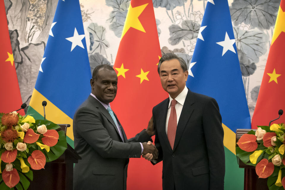 Solomon Islands Foreign Minister Jeremiah Manele, left, and Chinese Foreign Minister Wang Yi shake hands at a ceremony to mark the establishment of diplomatic relations between the Solomon Islands and China at the Diaoyutai State Guesthouse in Beijing, Saturday, Sept. 21, 2019. (AP Photo/Mark Schiefelbein, Pool)