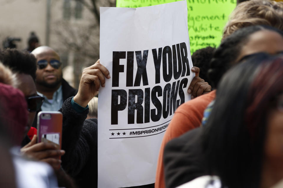 Several attendees waved posters calling for the state to "Fix your prisons," at a rally in front of the Mississippi Capitol in Jackson, on Friday, Jan. 24, 2020, protesting conditions in prisons where inmates have been killed in violent clashes in recent weeks. (AP Photo/Rogelio V. Solis)