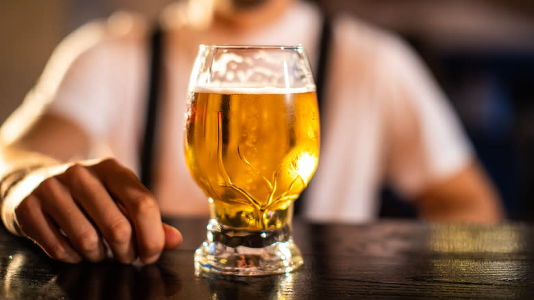 Person standing behind beer glass