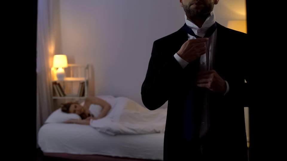 Man putting business suit on and leaving sleeping mistress in bed, cheating