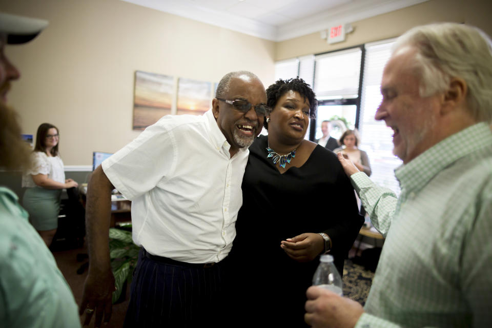 Georgia Democratic gubernatorial candidate Stacey Abrams, center, jokes with State Representative Al Williams, left, at the Coastal Solar office during a campaign stop to announce her "Jobs for Georgia Plan", Thursday, July 26, 2018, in Hinesville, Ga. (AP Photo/Stephen B. Morton)