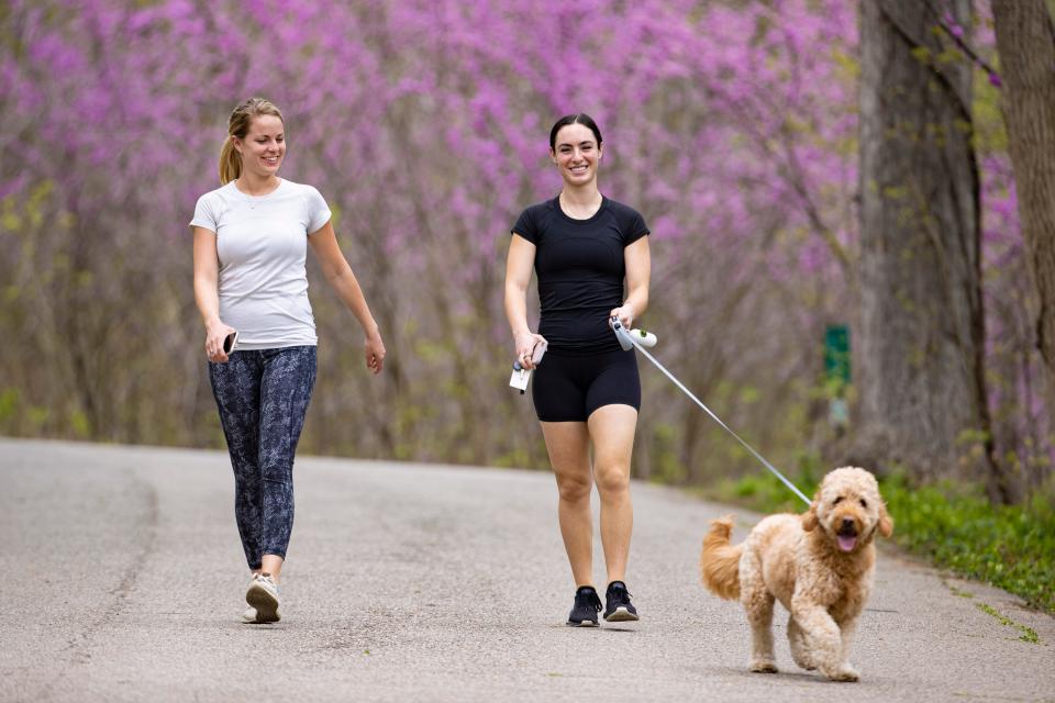 Monica Sokolik, left, and Christin Rutley walk through Cherokee Park with Rutley's dog Bron on Tuesday. April 7, 2020