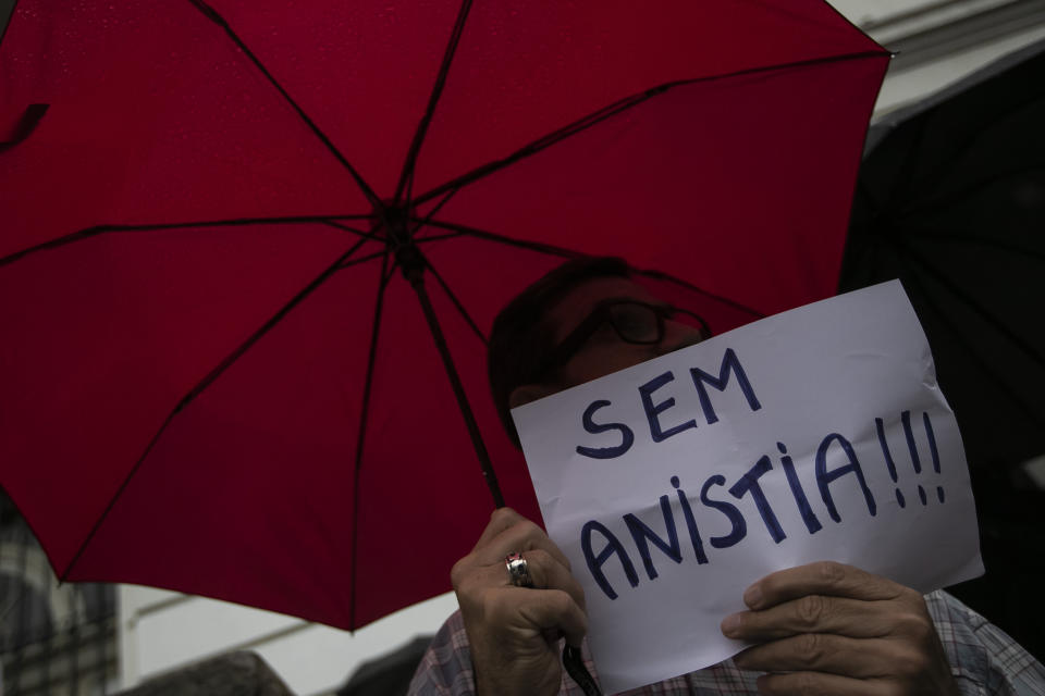 A man holds a sign that reads in Portugues: "No amnesty!!!" during an act in favor of Brazilian democracy in Rio de Janeiro, Brazil, Monday, Jan. 9, 2023, one day after Bolsonaro supporters stormed government buildings in the capital city of Brasilia. (AP Photo/Bruna Prado)