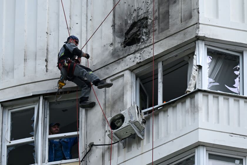 TOPSHOT - A specialist inspects the damaged facade of a multi-storey apartment building after a reported drone attack in Moscow on May 30, 2023. (Photo by Kirill KUDRYAVTSEV / AFP) (Photo by KIRILL KUDRYAVTSEV/AFP via Getty Images)