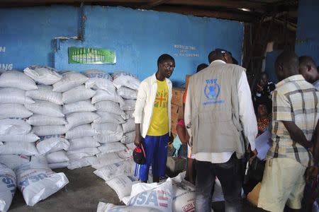 Volunteers distribute food at a World Food Programme storage center in Monrovia October 16, 2014. REUTERS/James Giahyue