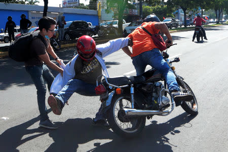 A demonstrator clashes with supporters of Nicaraguan President Daniel Ortega during a protest in Managua, Nicaragua October 14, 2018. REUTERS/Oswaldo Rivas