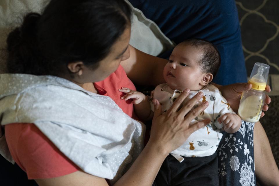 Yury Navas, 29, of Laurel, Md., cuddles with her two-month-old baby Ismael Galvaz, while feeding him a bottle of formula at their apartment in Laurel, Md., Monday, May 23, 2022. After this day's feedings she will be down to their last 12.5 ounce container of formula. Navas doesn't know why her breastmilk didn't come in for her third baby and has tried many brands of formula before finding the one kind that he could tolerate well, which she now says is practically impossible for her to find. To stretch her last can she will sometimes give the baby the water from cooking rice to sate his hunger. (AP Photo/Jacquelyn Martin)