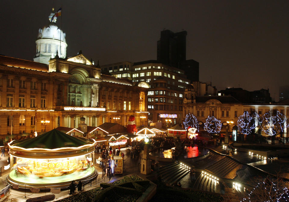 Christmas shoppers browse a German market and carousel in Birmingham, central England December 20, 2007.   REUTERS/Darren Staples   (BRITAIN)