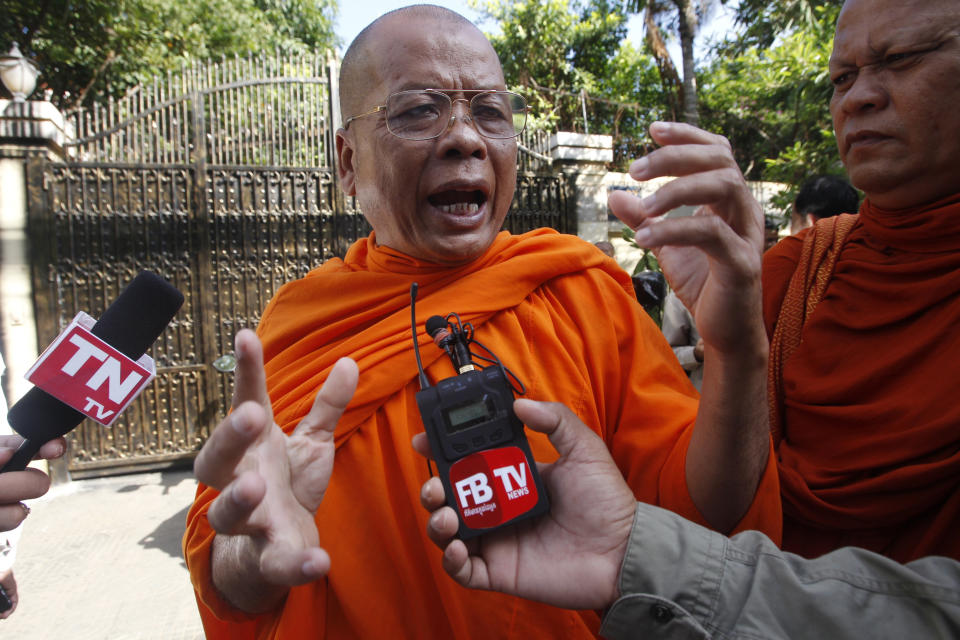 Cambodian Buddhist monk Sem Sovandy, center, talks with local journalists in front of the house of Kem Sokha, former leader of now dissolved opposition Cambodia National Rescue Party, in Phnom Penh, Cambodia, Monday, Sept. 10, 2018. Kem Sokha was released on bail Monday after being jailed for a year on a treason charge, a government spokesman said. A small crowd has gathered outside his home in Phnom Penh but so far he hasn’t been seen. His whereabouts are, as yet, unclear. (AP Photo/Heng Sinith)