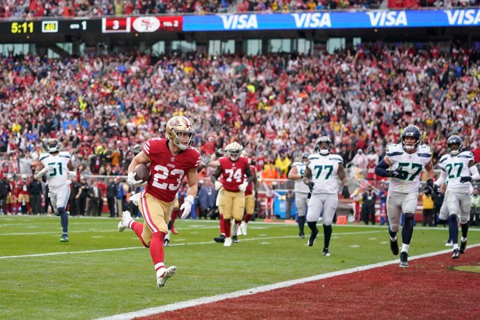 San Francisco 49ers running back Christian McCaffrey (23) scores a touchdown against the Seattle Seahawks during the first half of an NFL wild card playoff football game in Santa Clara, Calif., Saturday, Jan. 14, 2023.