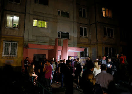 People gather outside an apartment block where Russian journalist Arkady Babchenko was shot and died of his wounds in an ambulance, in Kiev, Ukraine May 29, 2018. REUTERS/Gleb Garanich