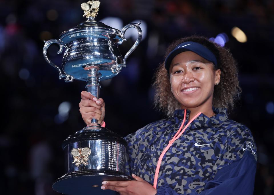 Naomi Osaka holds the trophy as she celebrates her Australian Open victory.