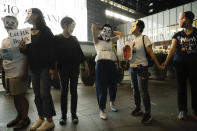 Protesters wear masks during a protest in Hong Kong, Friday, Oct. 18, 2019. Hong Kong pro-democracy protesters are donning cartoon/superhero masks as they formed a human chain across the semiautonomous Chinese city, in defiance of a government ban on face coverings. (AP Photo/Mark Schiefelbein)