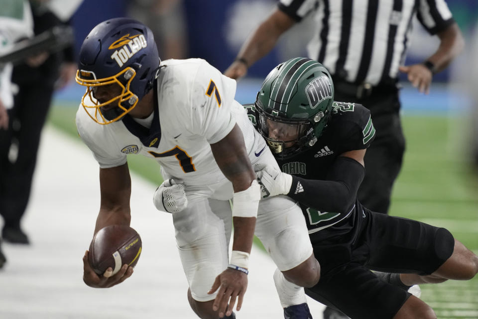 Toledo quarterback Dequan Finn (7) is pushed out of bounds by Ohio safety Adonis Williams Jr. (22) during the first half of the Mid-American Conference championship NCAA college football game, Saturday, Dec. 3, 2022, in Detroit. (AP Photo/Carlos Osorio)