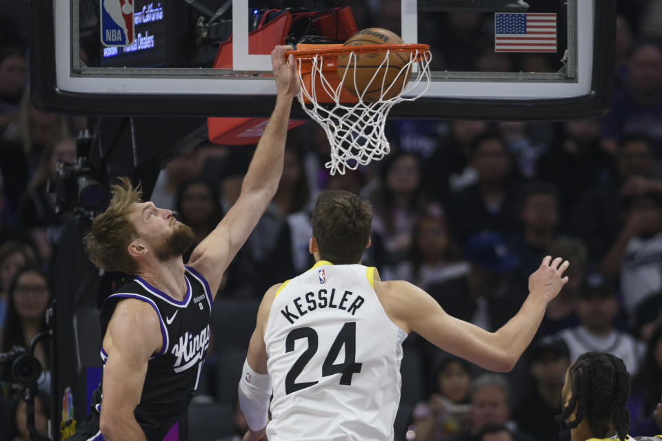 Sacramento Kings forward Domantas Sabonis, left, dunks the ball over Utah Jazz center Walker Kessler (24) during the first half of an NBA basketball game in Sacramento, Calif., Sunday, March 31, 2024. (AP Photo/Randall Benton)