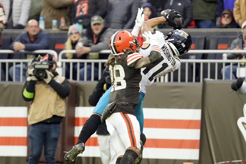 Jacksonville Jaguars wide receiver Parker Washington (11), defended by Cleveland Browns cornerback Mike Ford (28), catches a 19-yard pass fora touchdown during the second half of an NFL football game, Sunday, Dec. 10, 2023, in Cleveland. (AP Photo/Sue Ogrocki)