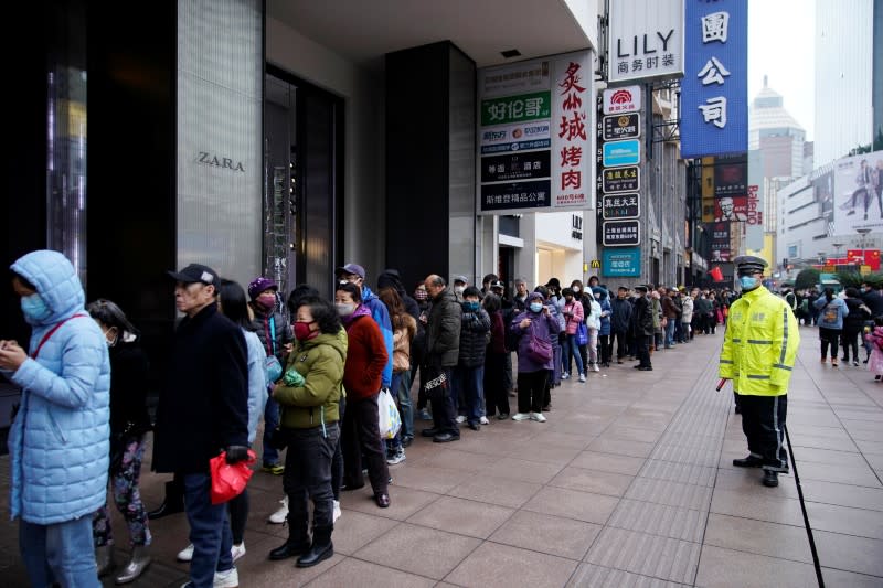 People line up outside a drugstore to buy masks in Shanghai